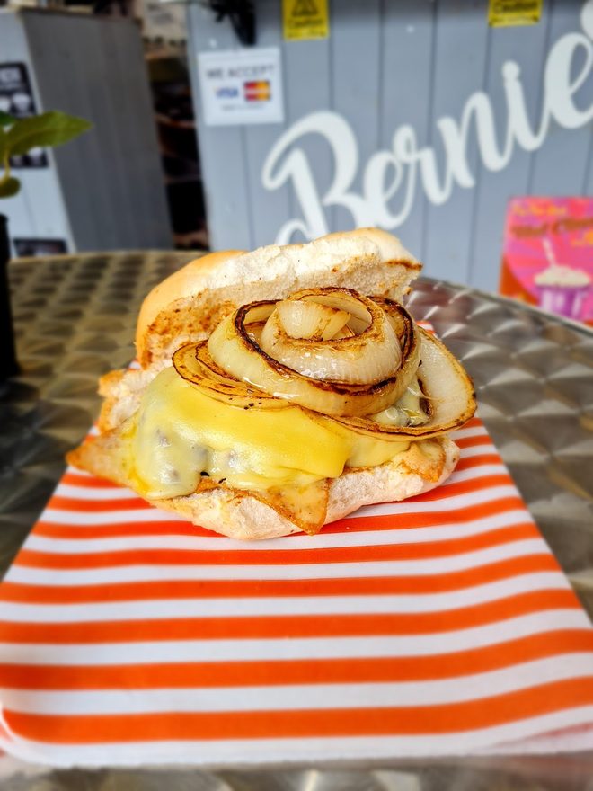 A toasted cheese and onion roll on a metal table