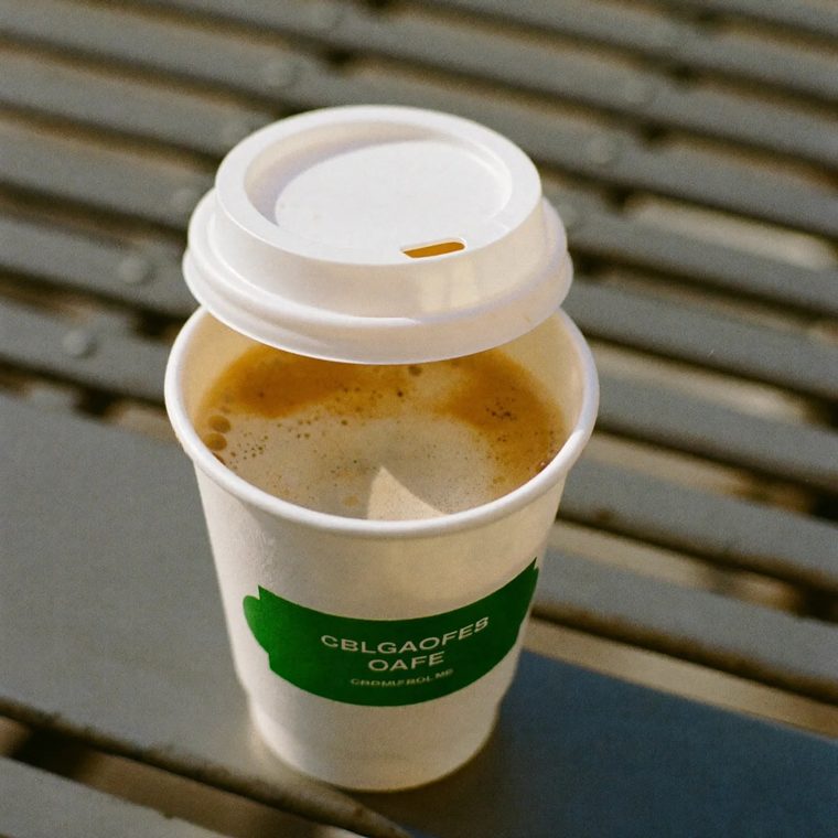 A hot takeaway coffee on a metal outdoor table
